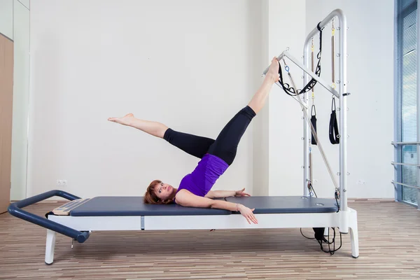 Gym woman pilate instructor stretching in reformer bed — Stock Photo, Image