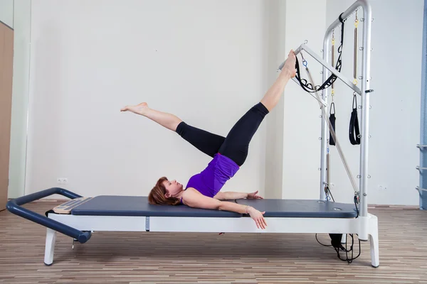 Gym woman pilate instructor stretching in reformer bed — Stock Photo, Image