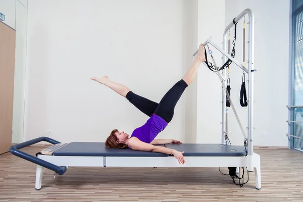 Gym woman pilate instructor stretching in reformer bed — Stock Photo, Image