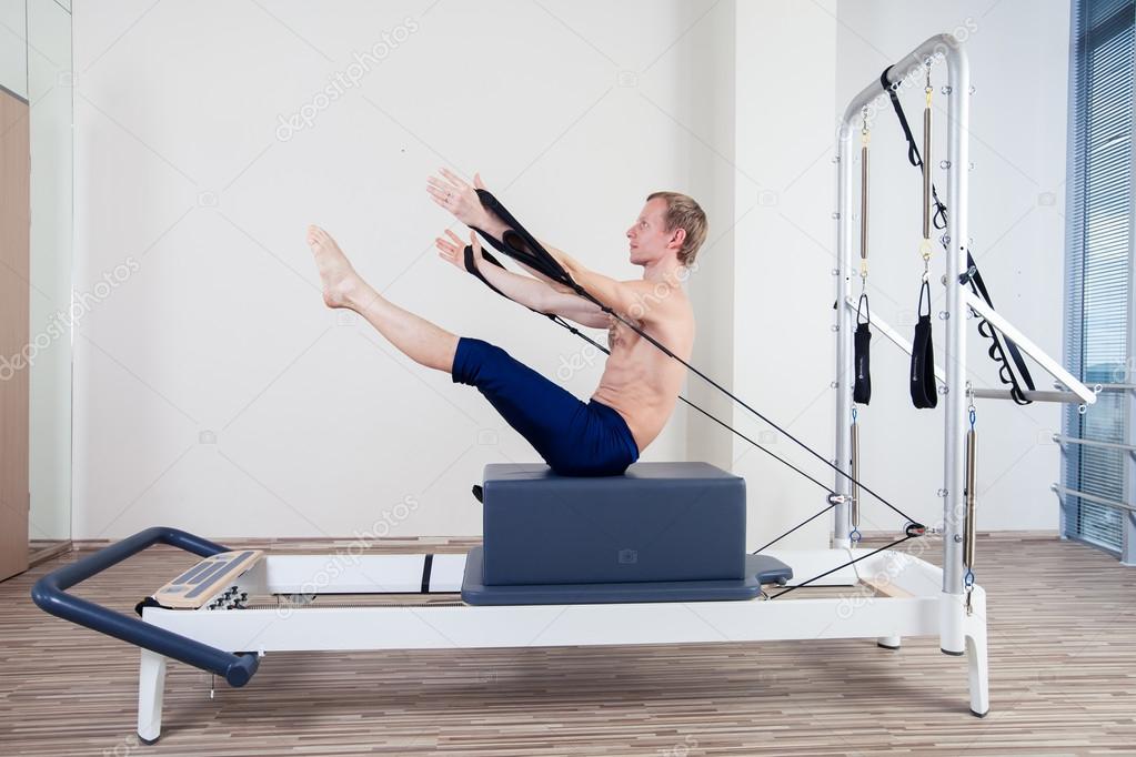 Pilates reformer workout exercises man at gym indoor Stock Photo by