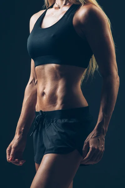 Ritratto donna sportiva con indosso abbigliamento sportivo nero sopra scuro — Foto Stock