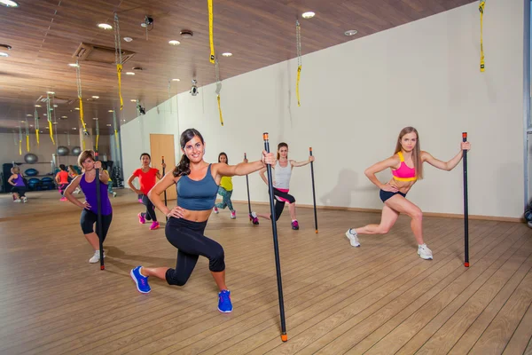 Fitness, esporte, treinamento e conceito de estilo de vida - grupo de mulheres sorridentes que se alongam no ginásio — Fotografia de Stock