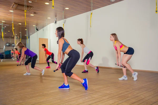 Fitness, deporte, entrenamiento y estilo de vida - grupo de mujeres sonrientes que se estiran en el gimnasio — Foto de Stock