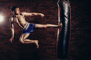 uygulama sırasında güçlü bir ileri tekme ile boks torbası, yuvarlak veren kas yakışıklı savaşçı kickboks