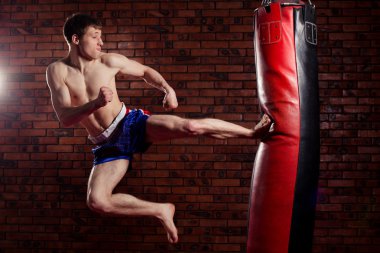 uygulama sırasında güçlü bir ileri tekme ile boks torbası, yuvarlak veren kas yakışıklı savaşçı kickboks