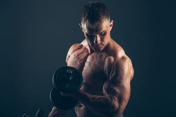 Mięsień mężczyzna robi biceps loki. — Zdjęcie stockowe