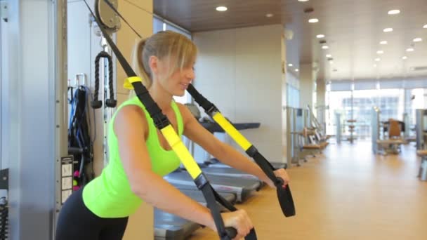 Młoda atrakcyjna kobieta rdzeń abs Krzyś szkolenia ukośne paski trx fitness Studio sale gimnastyczne — Wideo stockowe