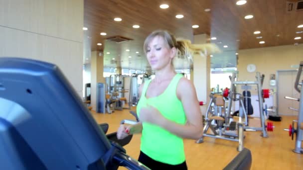 Young woman running on treadmill — Stock Video