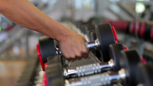 Mancuernas con la mano.Cierra.Brazo muscular en el gimnasio. Entrenamiento, deportes, manos, pesas, entrenamientos. - El concepto de un estilo de vida saludable y aptitud física. artículo sobre fitness y deportes . — Vídeo de stock