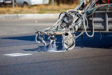 Teamwork: Pavement Asphalt Road Marking Paint and Striping with Thermoplastic Spray Applicator Machine during highway construction works