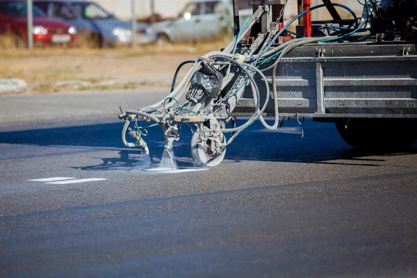 Trabajo en equipo: Pintura y rayado de asfalto de asfalto en carretera con aplicador de aerosol termoplástico durante las obras de construcción de carreteras — Foto de Stock