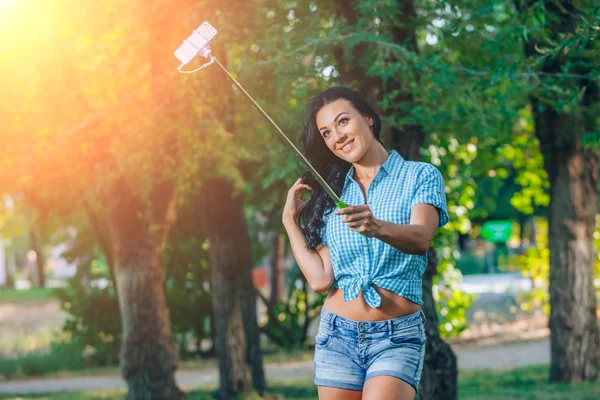 Mulheres segurar monopoda usar telefone inteligente tirar foto vara selfie no parque — Fotografia de Stock