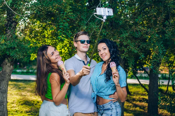 Group of friends taking picture themselves with monopod use smart phone take photograph selfie stick in park — Stock Fotó