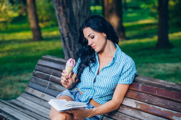 Young woman with book on the bench — Stock fotografie