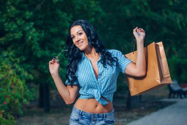 Portret van een vrolijke jonge vrouw met shopping tassen