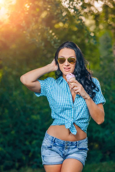 Портрет молодой счастливой женщины, кушающей мороженое на открытом воздухе — стоковое фото