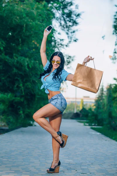 Portret van een vrolijke jonge vrouw met shopping tassen — Stok fotoğraf