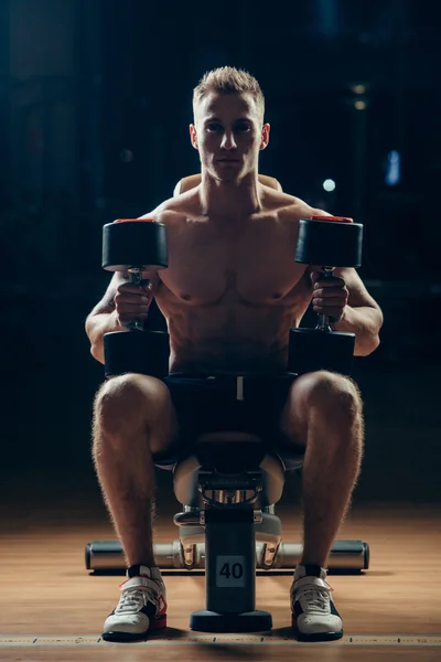 Atleta musculoso culturista entrenamiento de nuevo con mancuerna en el gimnasio —  Fotos de Stock