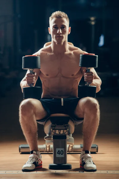 Athlete muscular bodybuilder training back with dumbbell  in the gym — Stock Photo, Image