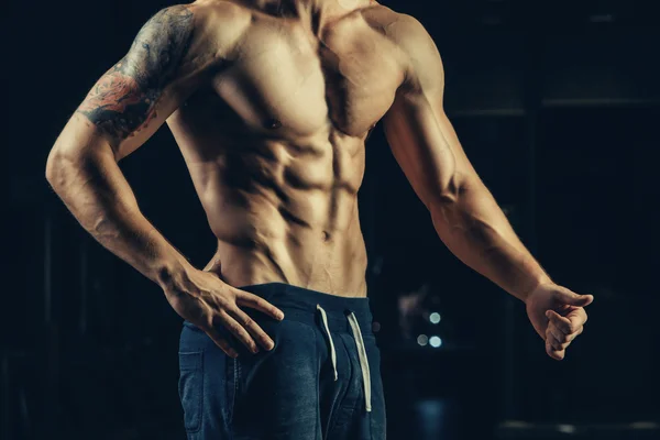 La silueta de un atleta. Joven hombre de fitness seguro con manos fuertes. Luz dramática . —  Fotos de Stock