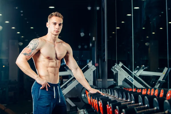 Hombre atleta con una mancuerna en el gimnasio se inclinan en la fila —  Fotos de Stock