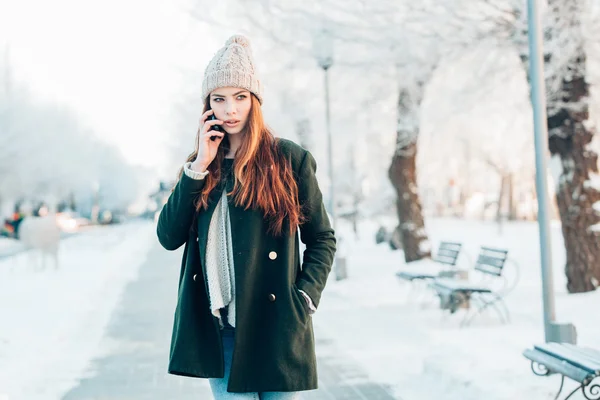Young  woman smiling with smart phone and winter landscape . — Stock Photo, Image