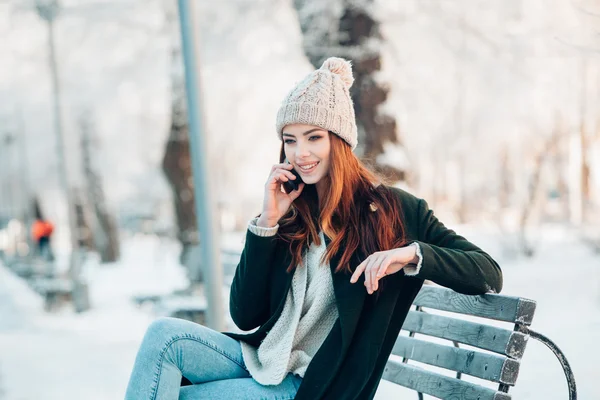 Fiatal nő, mosolygós, szúró telefon és a téli táj . — Stock Fotó