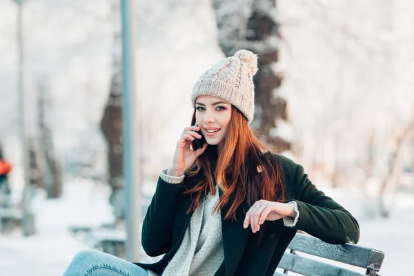 Fiatal nő, mosolygós, szúró telefon és a téli táj . — Stock Fotó