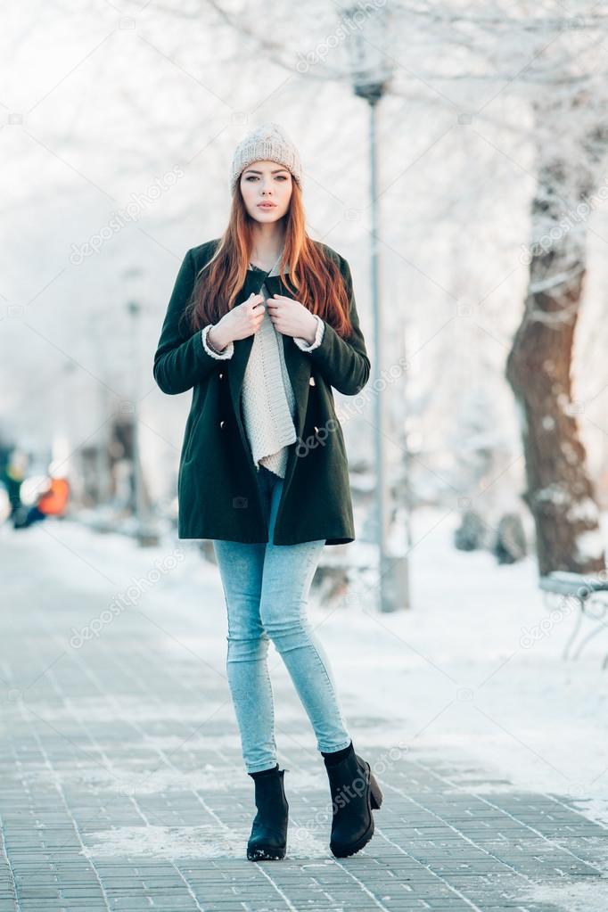 Beautiful winter portrait of young woman in the snowy scenery