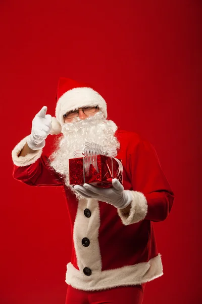 親切なサンタ クロース クリスマス プレゼントとカメラ目線の写真. — ストック写真