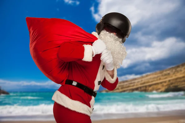 Cool Père Noël avec un sac cadeaux dans le casque Jets. dans le contexte de la mer — Photo