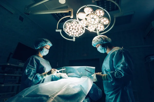 Equipe de Cirurgiões trabalhando com Monitoramento da paciente em sala de cirurgia cirúrgica.Aumento da mama . — Fotografia de Stock