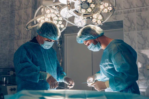 外科医生团队合作监测病人的外科手术室。隆胸 — 图库照片