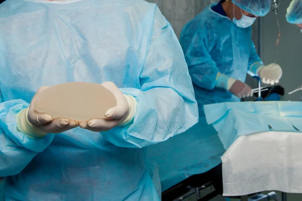 Team chirurg op het werk in de operatiekamer. borstvergroting. — Stockfoto