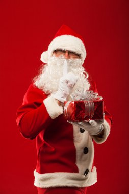 Fotoğraf tür Santa Claus xmas hediye veriyor ve kameraya bakıyor. gizli el dudaklar.