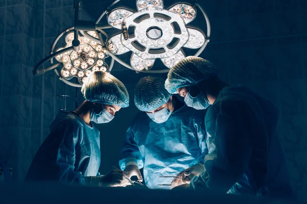 Equipe de Cirurgiões que trabalha com Monitoramento do paciente em centro cirúrgico. aumento da mama — Fotografia de Stock