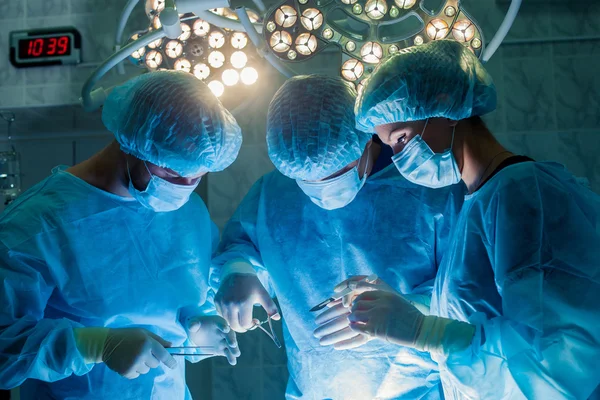 Equipe de Cirurgiões que trabalha com Monitoramento do paciente em centro cirúrgico. aumento da mama — Fotografia de Stock