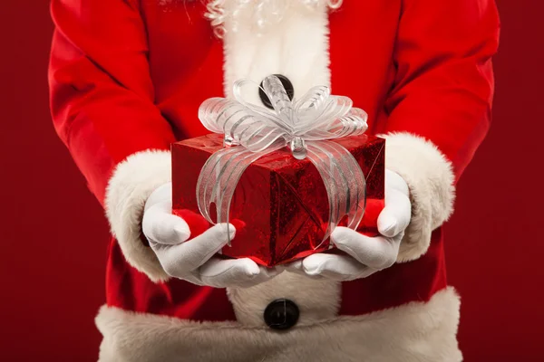 Foto de tipo Santa Claus dando regalo de Navidad y mirando a la cámara . — Foto de Stock