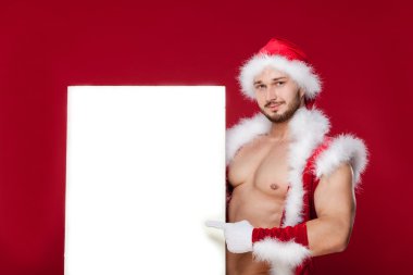 çok kaslı yakışıklı seksi Noel Baba kırmızı arka plan, tutun afiş ve gülümseme, izole bronzlaşmış