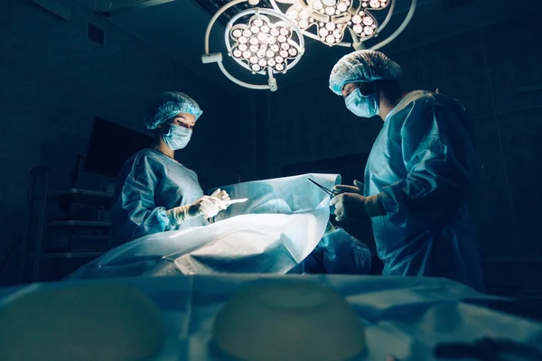 Chirurgen team dat werkt met Monitoring van patiënt in chirurgische operationele room.breast vergroting. — Stockfoto