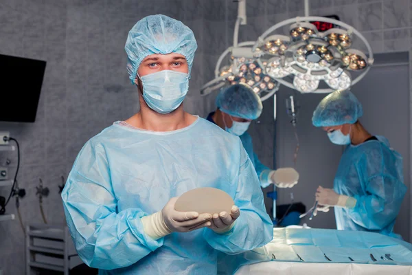 Chirurgien d'équipe au travail en salle d'opération. augmentation mammaire . — Photo