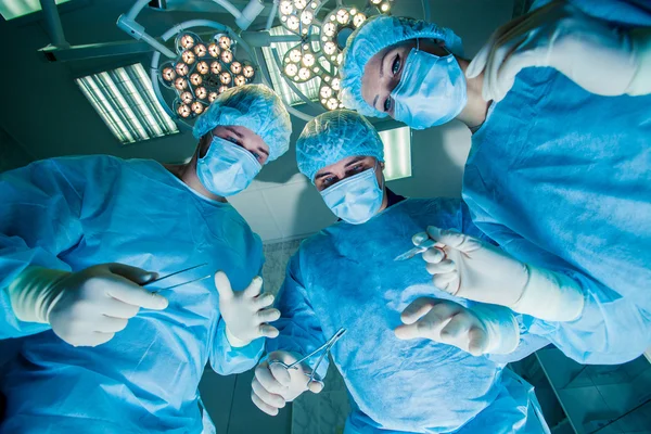 Cirurgiões em pé acima do paciente antes da cirurgia — Fotografia de Stock