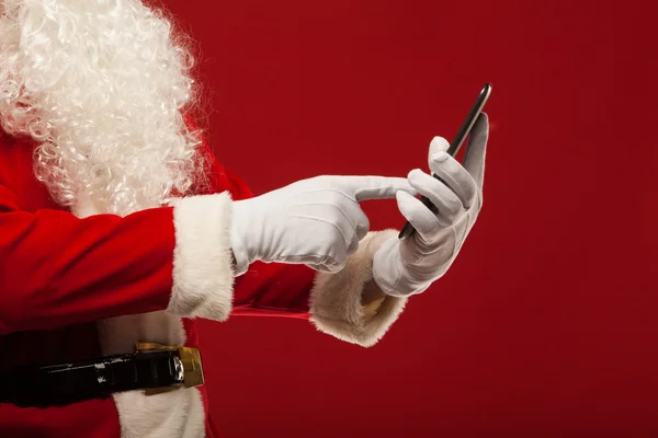 Moderní santa claus pomocí počítače tablet pc na červeném pozadí. Vánoční — ストック写真