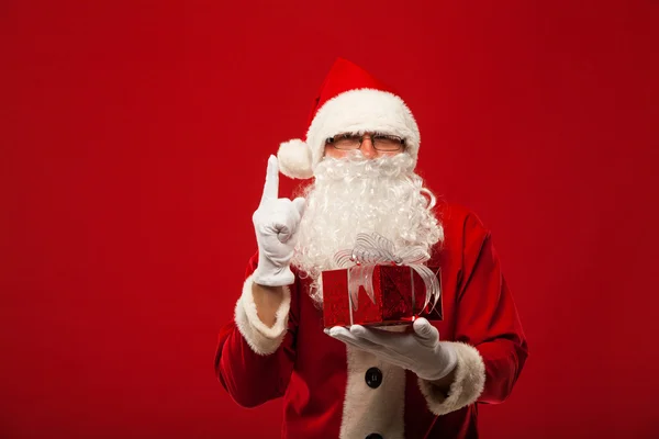 Photo of kind Santa Claus giving xmas present and looking at camera. — Stock Photo, Image