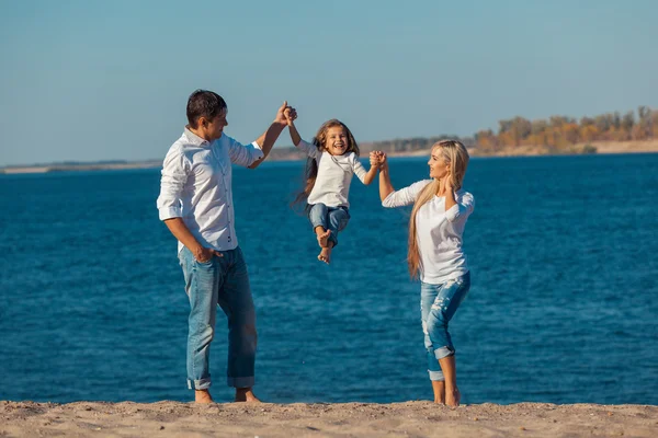 Familia feliz que juega en la playa. Concepto de familia amistosa —  Fotos de Stock