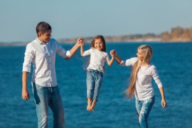 Mutlu aile kumsalda oynarken. Dost familys kavramı