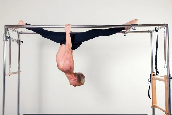 Pilates instructor aeróbico hombre en el ejercicio de fitness de cadillac acrobático al revés equilibrio — Foto de Stock