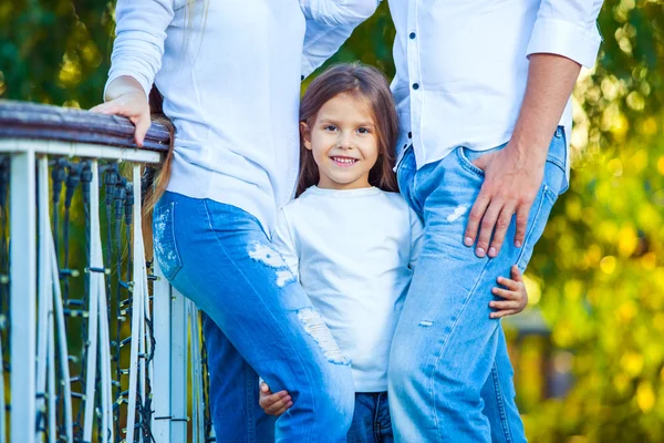 Muy linda niña rubia sosteniendo el pie mamá y papá. abrazo —  Fotos de Stock