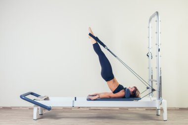 Kapalı spor salonunda Pilates reformer Egzersiz Egzersizler kadın esmer