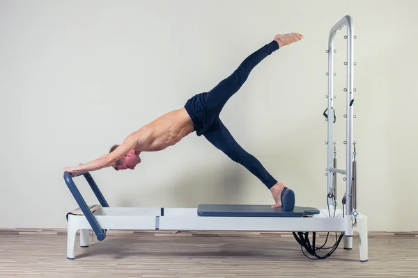 Reformátor cvičení Pilates cvičení člověka v tělocvičně krytého — Stock fotografie